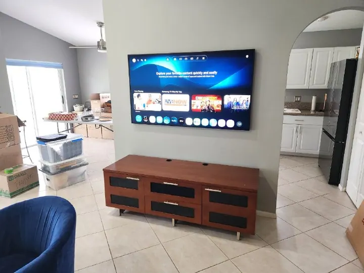 Wall-mounted Samsung television above a wood media console in an open living room