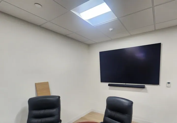 Large wall-mounted conference-room display with soundbar beneath it